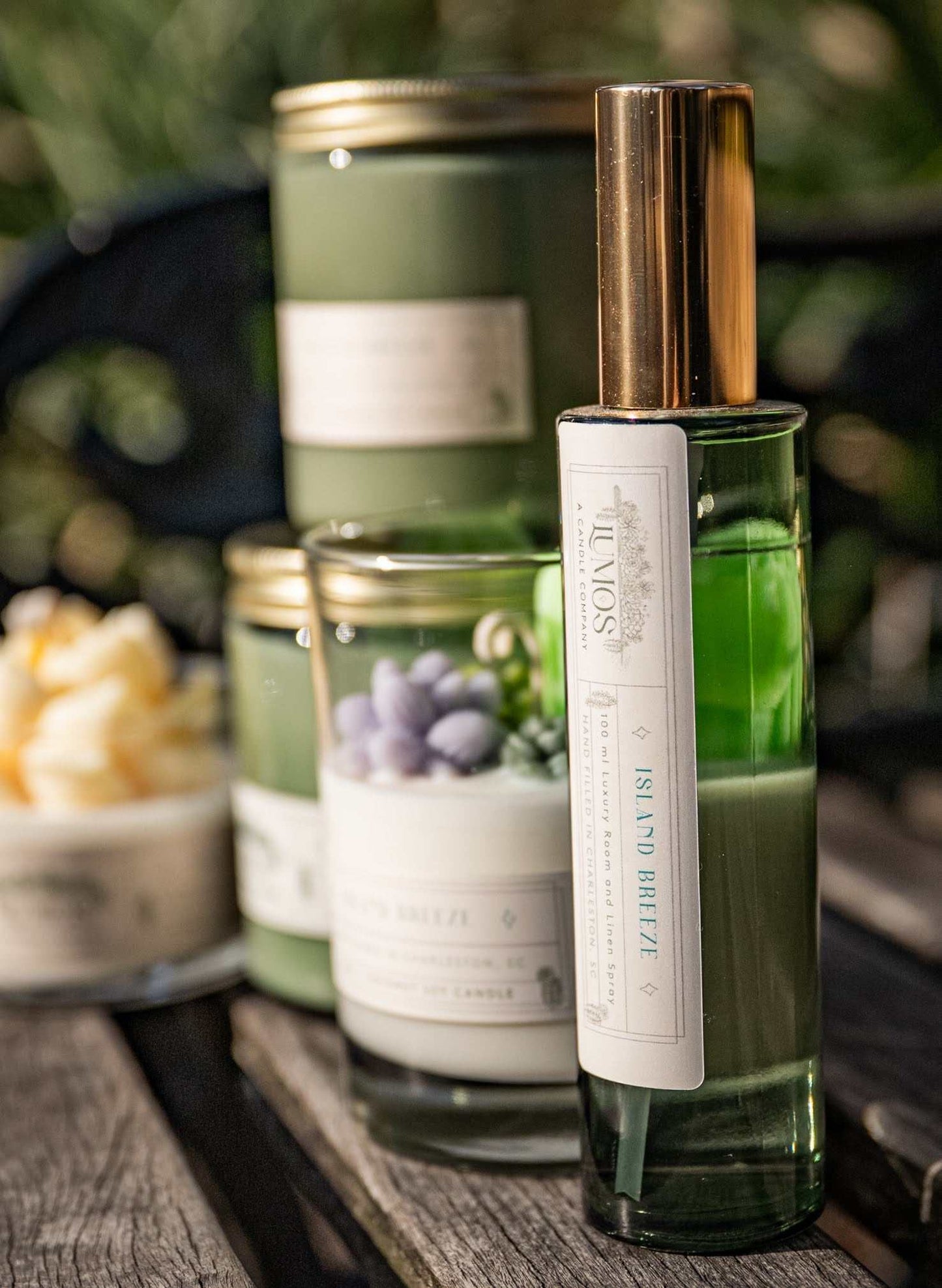 LUMOS Room + Linen Spray luxury home fragrance mist in elegant glass bottle with gold sprayer, available in three signature scents.