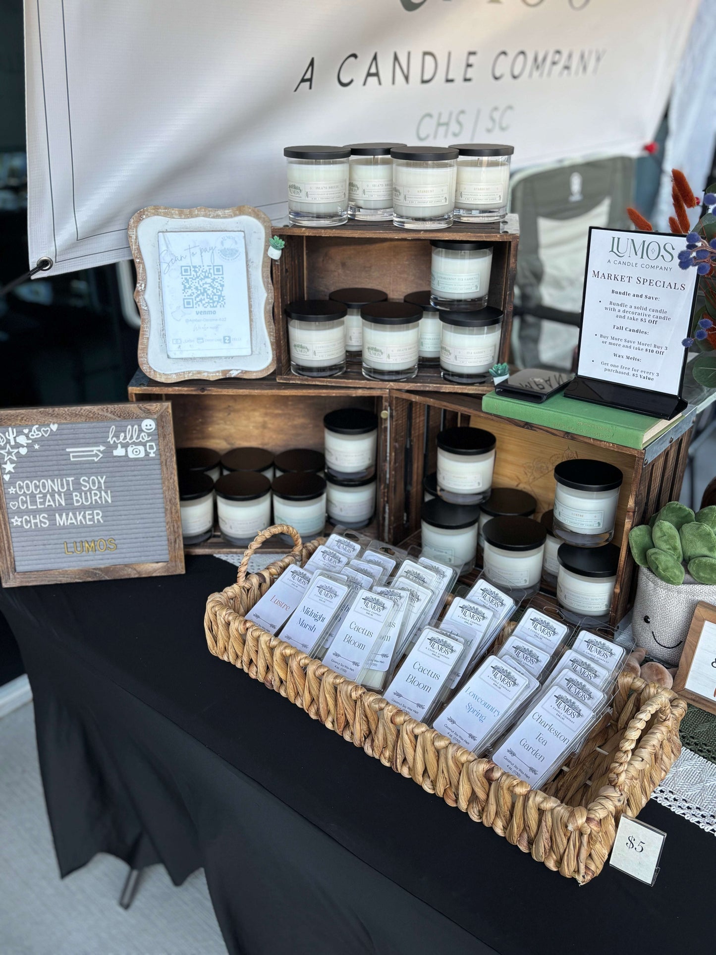 LUMOS Hand-Poured coconut soy candles in glass jars with black lids displayed at market booth