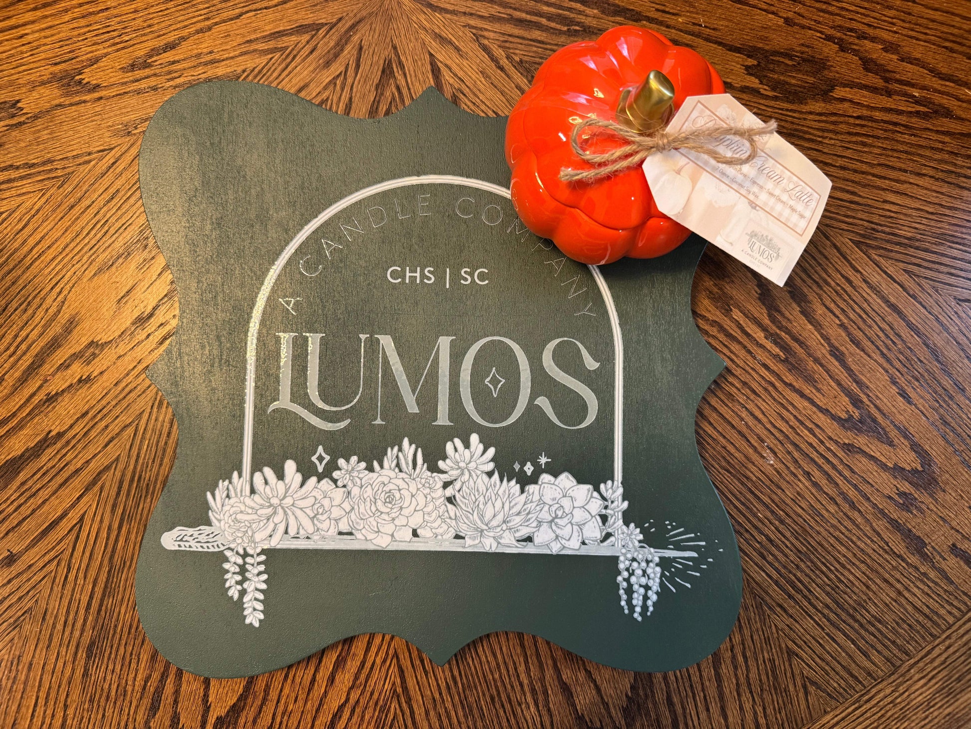 Limited edition 7oz fall scented candle in orange pumpkin ceramic vessel by Lumos on wooden table