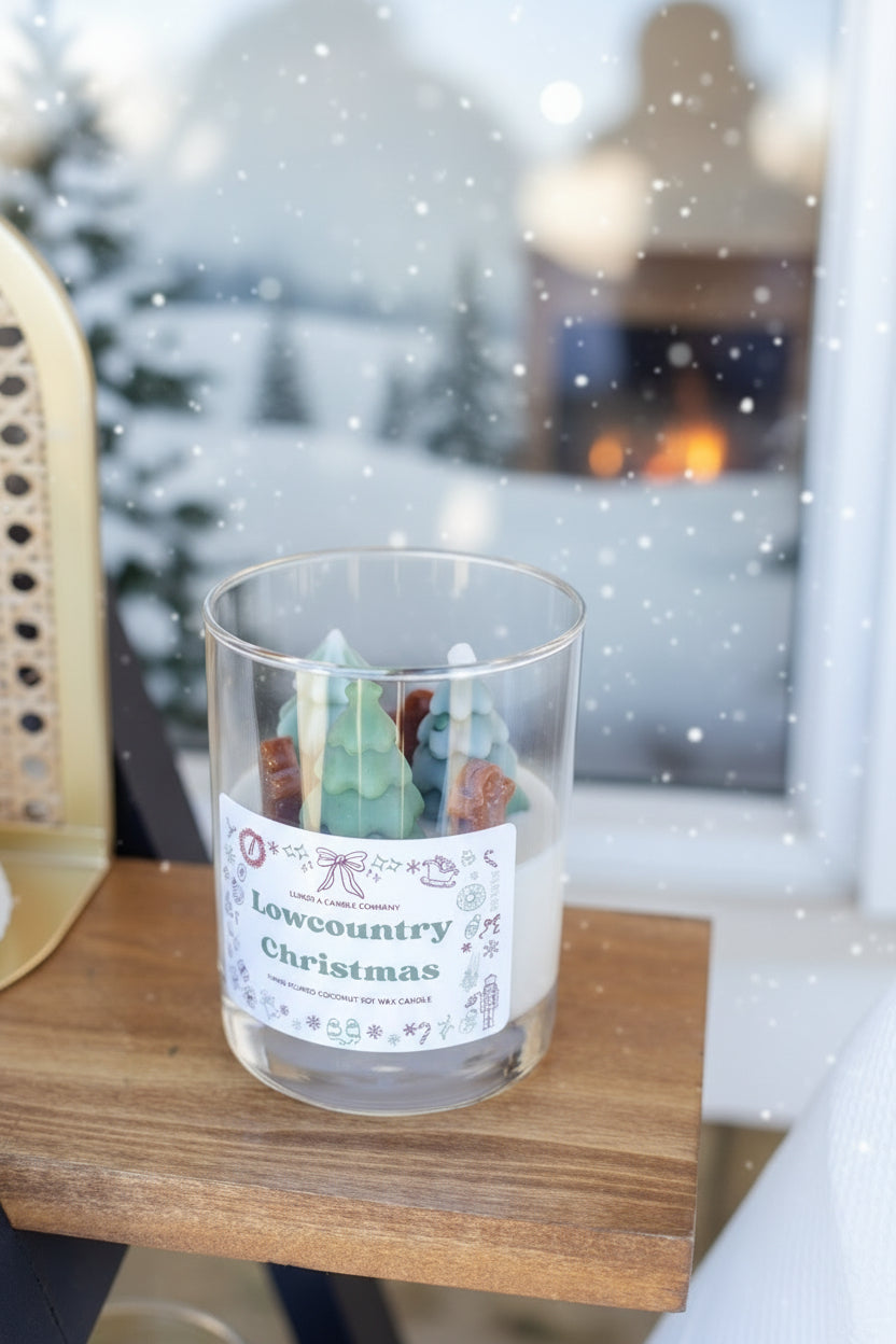 Candle in a glass jar labeled 'Lowcountry Christmas' on a wooden surface.