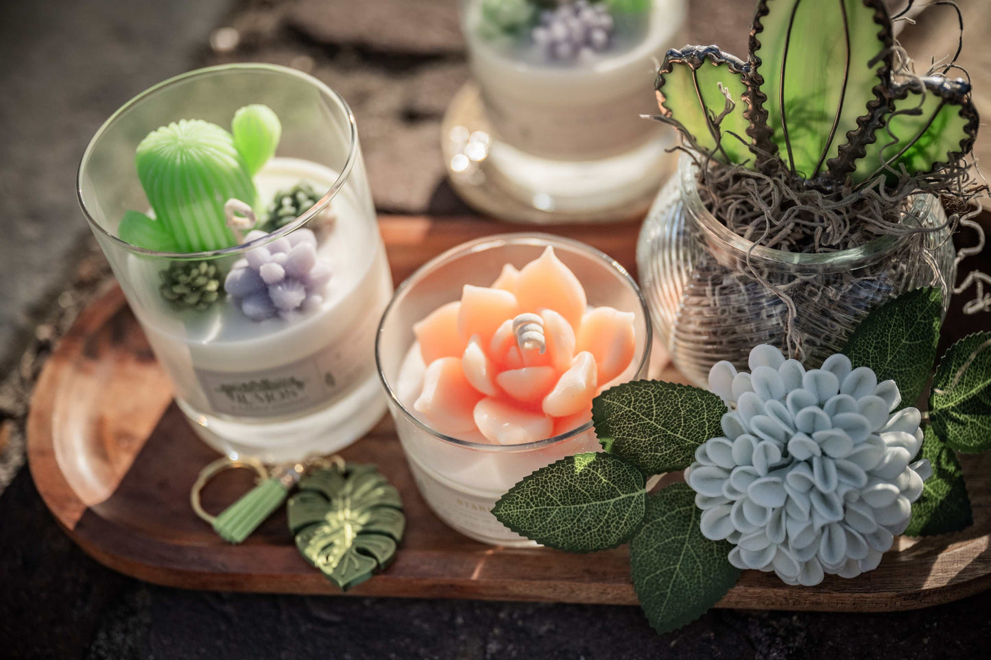 Decorative items including small plants and flowers on a wooden tray.