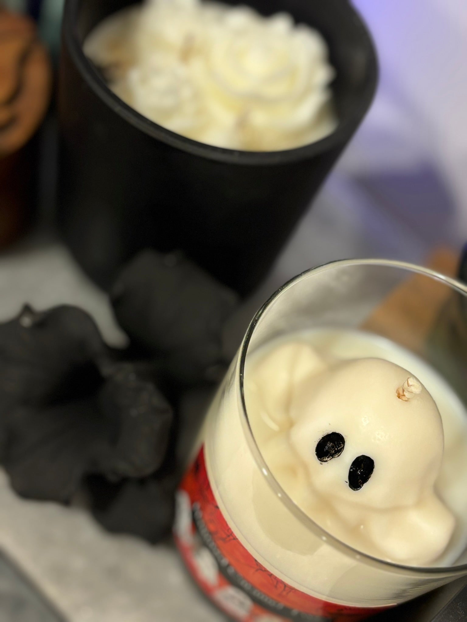 Ghost-shaped candle in a glass with a blurred background