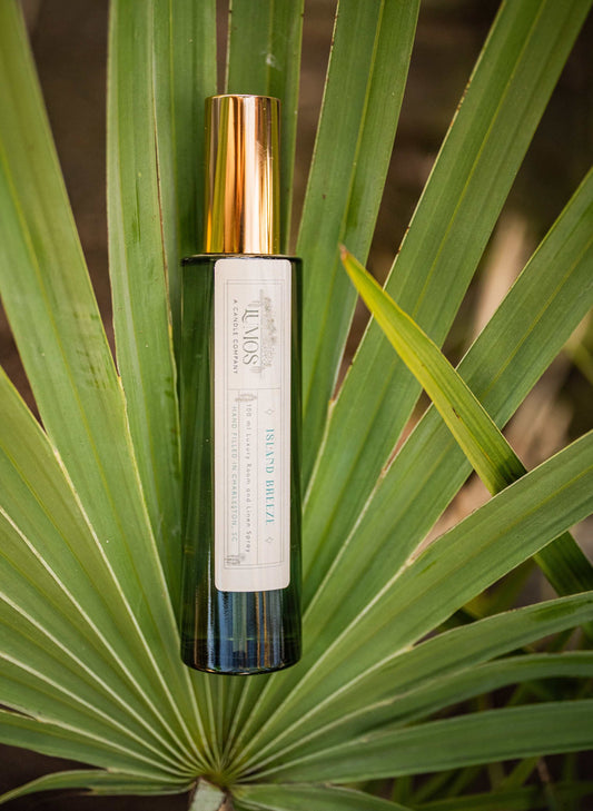 Green bottle with gold cap on a palm leaf