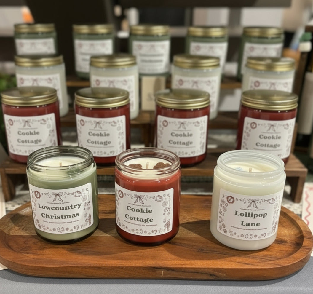 Assorted candles on a wooden tray with visible labels on a table.