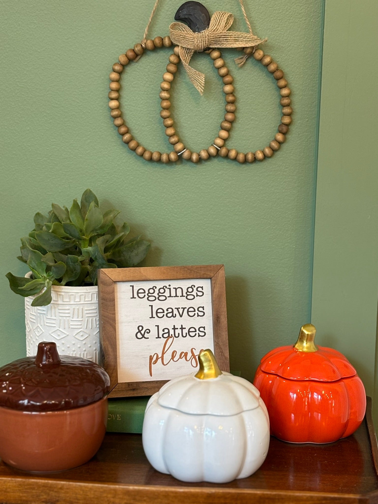 Brown acorn, white pumpkin, and orange pumpkin ceramic vessels with LUMOS fall scented coconut soy candles