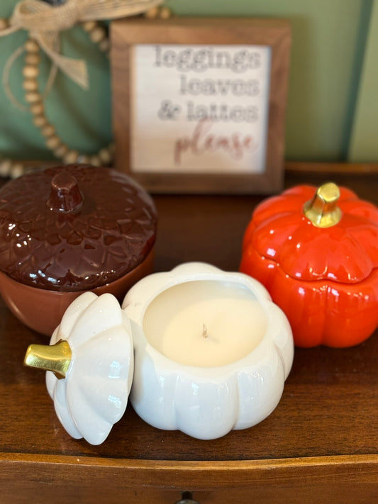 Brown acorn, white pumpkin, and orange pumpkin ceramic vessels with LUMOS fall scented soy candles