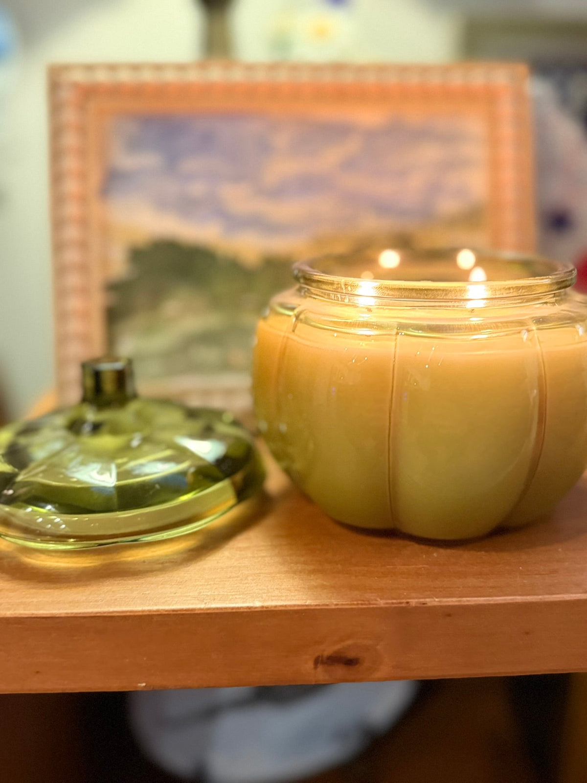 14 oz Green Glass Pumpkin Candle in pale green glass, pumpkin-shaped vessel with a rounded body and two lit wicks.